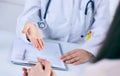 Female doctor giving a consultation to a patient and explaining medical informations and diagnosis. Just hands over the Royalty Free Stock Photo