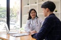 Female doctor giving encouragement to male patient by holding hand and a shoulder tap