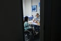 Female doctor giving prescription to disabled female patient at desk Royalty Free Stock Photo
