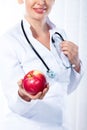 Female doctor giving red apple Royalty Free Stock Photo