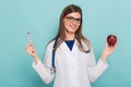 Female doctor in glasses with apple and pills Royalty Free Stock Photo