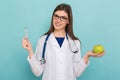 Female doctor in glasses with apple and pills Royalty Free Stock Photo