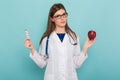 Female doctor in glasses with apple and pills Royalty Free Stock Photo