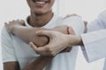 Female doctor hand doing physical therapy By extending the shoulder of a male patient Royalty Free Stock Photo