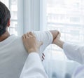 Female doctor hand doing physical therapy By extending the shoulder of a male patient Royalty Free Stock Photo