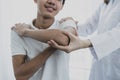 Female doctor hand doing physical therapy By extending the shoulder of a male patient Royalty Free Stock Photo