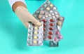 Female doctor hand hold pack of different tablet blisters at workplace. Panacea, life save service, prescribe medicament