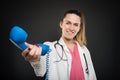 Female doctor handing big blue telephone receiver and smiling