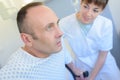 Female doctor handing crutches to male patient