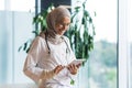 Female doctor in hijab works in modern clinic office, Muslim female doctor uses tablet computer, nurse in medical white Royalty Free Stock Photo