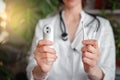 Female doctor hold various thermometers. People and healthcare concept. Coronavirus. Green leaves on background