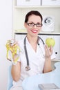 Female doctor holding apple and measuring tape. Royalty Free Stock Photo