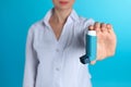 Female doctor holding asthma inhaler on color background. Medical object Royalty Free Stock Photo