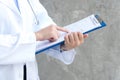 Female doctor holding blue clipboard and reading something. Healthcare and medical concept Royalty Free Stock Photo