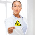 Female doctor holding boihazard caution sign Royalty Free Stock Photo