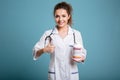 Female doctor holding bottle of pills and showing thumb up Royalty Free Stock Photo