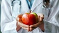 Female doctor holding fresh organic red apple with care and compassion