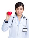 Female doctor holding heart shape ball
