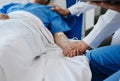 Female doctor holding male patient hand on the bed with receiving saline solution in hospital Royalty Free Stock Photo