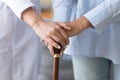 Female doctor holding old woman patient hand with cane stick Royalty Free Stock Photo