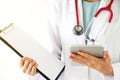 Female doctor holding patient medical chart and tablet computer Royalty Free Stock Photo