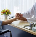 Female doctor holding patient`s hand for encouragement and empathy and touching her arm. Partnership, trust and medical Royalty Free Stock Photo