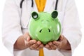 Female doctor holding piggy bank Royalty Free Stock Photo