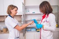 Female doctor holding preparing a syringe while talking to a nurse Royalty Free Stock Photo