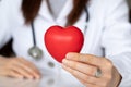 Female doctor holding red heart in hands while working in hospital Royalty Free Stock Photo