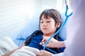 Female doctor holding a stethoscope to check the health of a cute little Asian girl Royalty Free Stock Photo