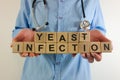 Female doctor holding text yeast infection from wooden blocks