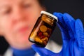 Female doctor holding unlabeled bottle of various pills and medi Royalty Free Stock Photo