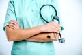 A female doctor holds a black phonendoscope in her hands.