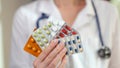 Female doctor holds blisters of pills and vitamins in hand