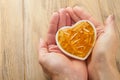 Female or doctor holds in hand capsules with Vitamin D, E or Omega 3,6,9 fatty acids in heart shape bowl. Food supplement oil Royalty Free Stock Photo