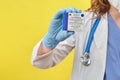 A female doctor holds in her hand a pack of ampoules for vaccination Sputnik V, yellow studio background - Moscow, Russia,