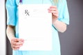 Female doctor holds prescription form while standing straight in hospital closeup. Healthcare, insurance and excellent