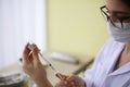 Female doctor holds syringe and bottle with vaccine for coronavirus cure. Concept of corona virus treatment Royalty Free Stock Photo