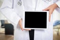 A female doctor holds a tablet in the examination room