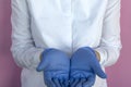 Female doctor in blue latex gloves shows hands