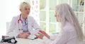 Female doctor listens, elderly woman talks about chronic diseases health complaints symptoms of ailment