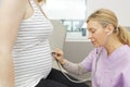 female doctor listens pregnant belly Royalty Free Stock Photo