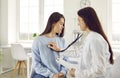 Female doctor listens to patient& x27;s breathing by applying stethoscope to her chest. Royalty Free Stock Photo