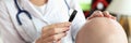 Female doctor looks at skin of bald patient through magnifying glass. Royalty Free Stock Photo