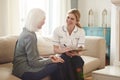 Female Doctor Making Home Visit To Senior Woman For Medical Check