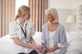 Female Doctor Making Home Visit To Senior Woman For Medical Check Offering Reassurance Royalty Free Stock Photo