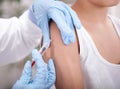 Female doctor making injection to little boy