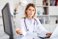 Female doctor making welcome gesture, politely inviting patient in office