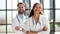 a female doctor and a male doctor are standing in the office with their arms crossed Royalty Free Stock Photo