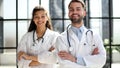 a female doctor and a male doctor are standing in the office with their arms crossed Royalty Free Stock Photo